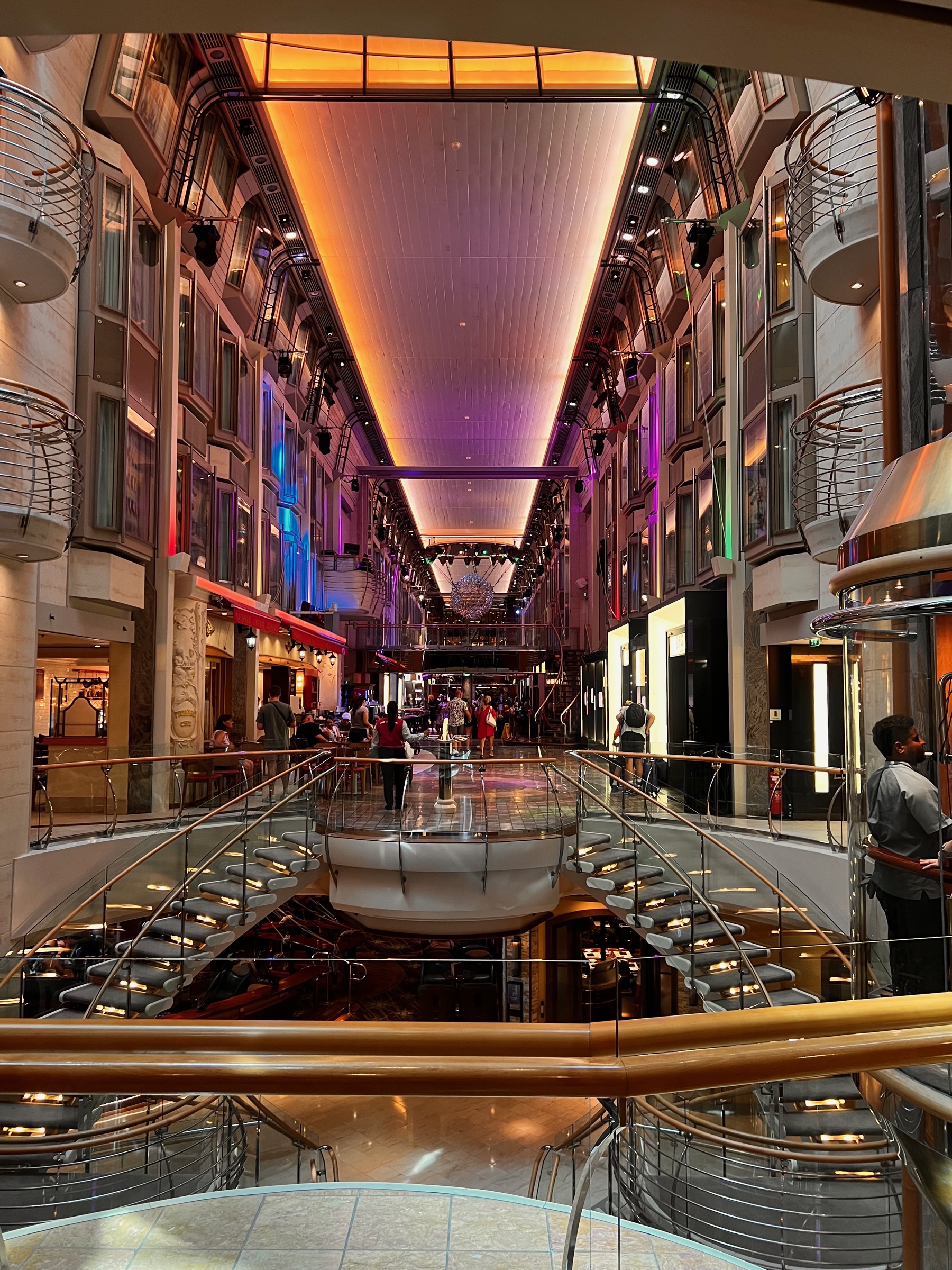 The illuminated multi-level Royal Promenade aboard Explorer of the Seas