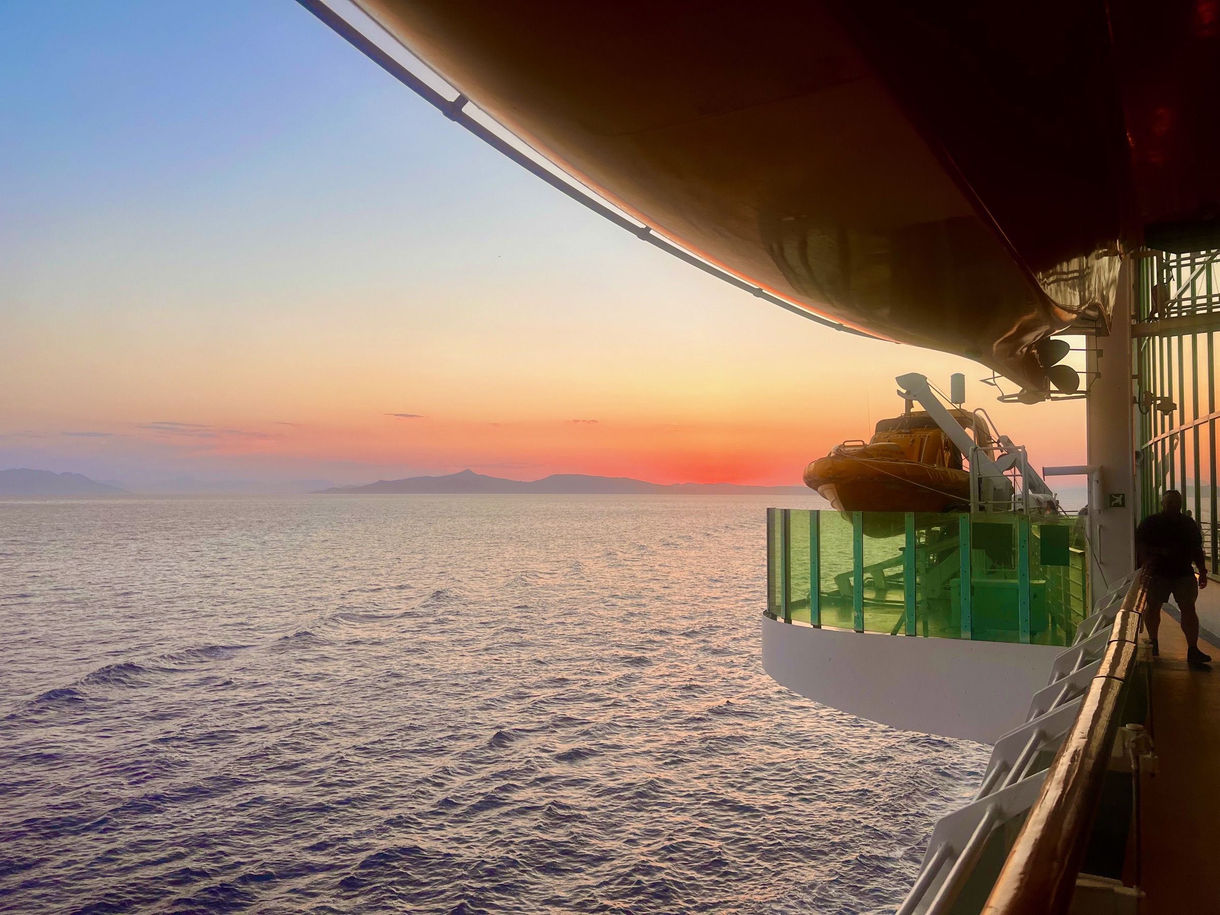 A glowing Mediterranean sunset viewed beside a lifeboat on Explorer of the Seas