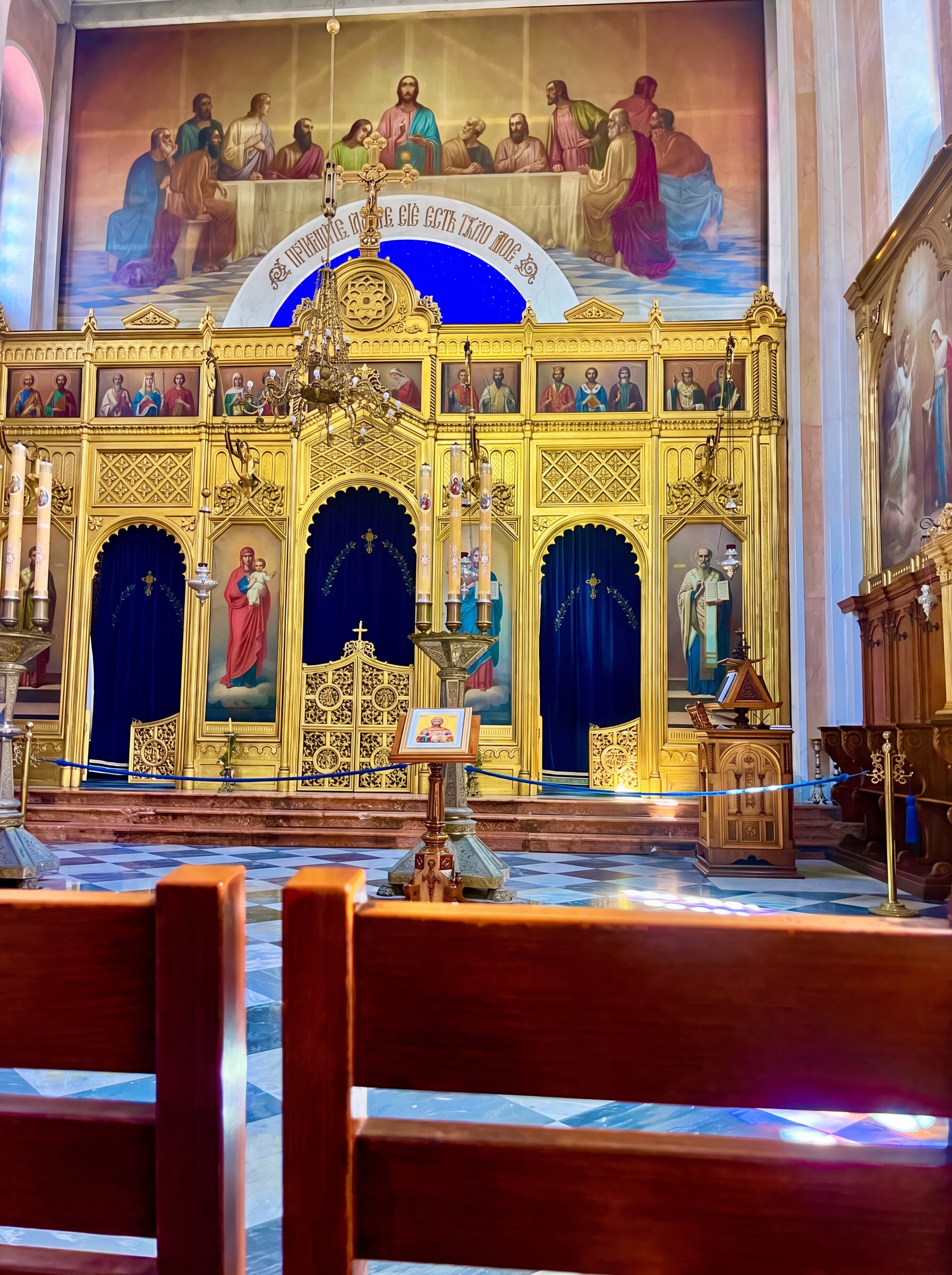 Ornate church sanctuary in Dubrovnik with gold icon panels and deep blue curtains