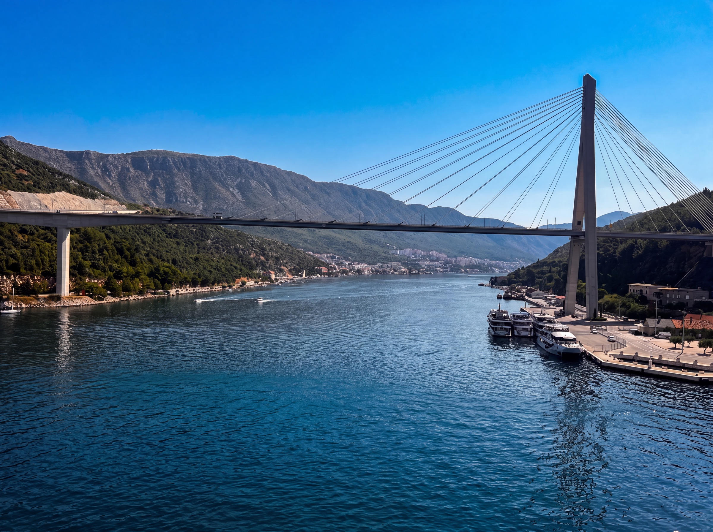 Franjo Tudman Bridge crossing Dubrovnik's harbor with mountains beyond
