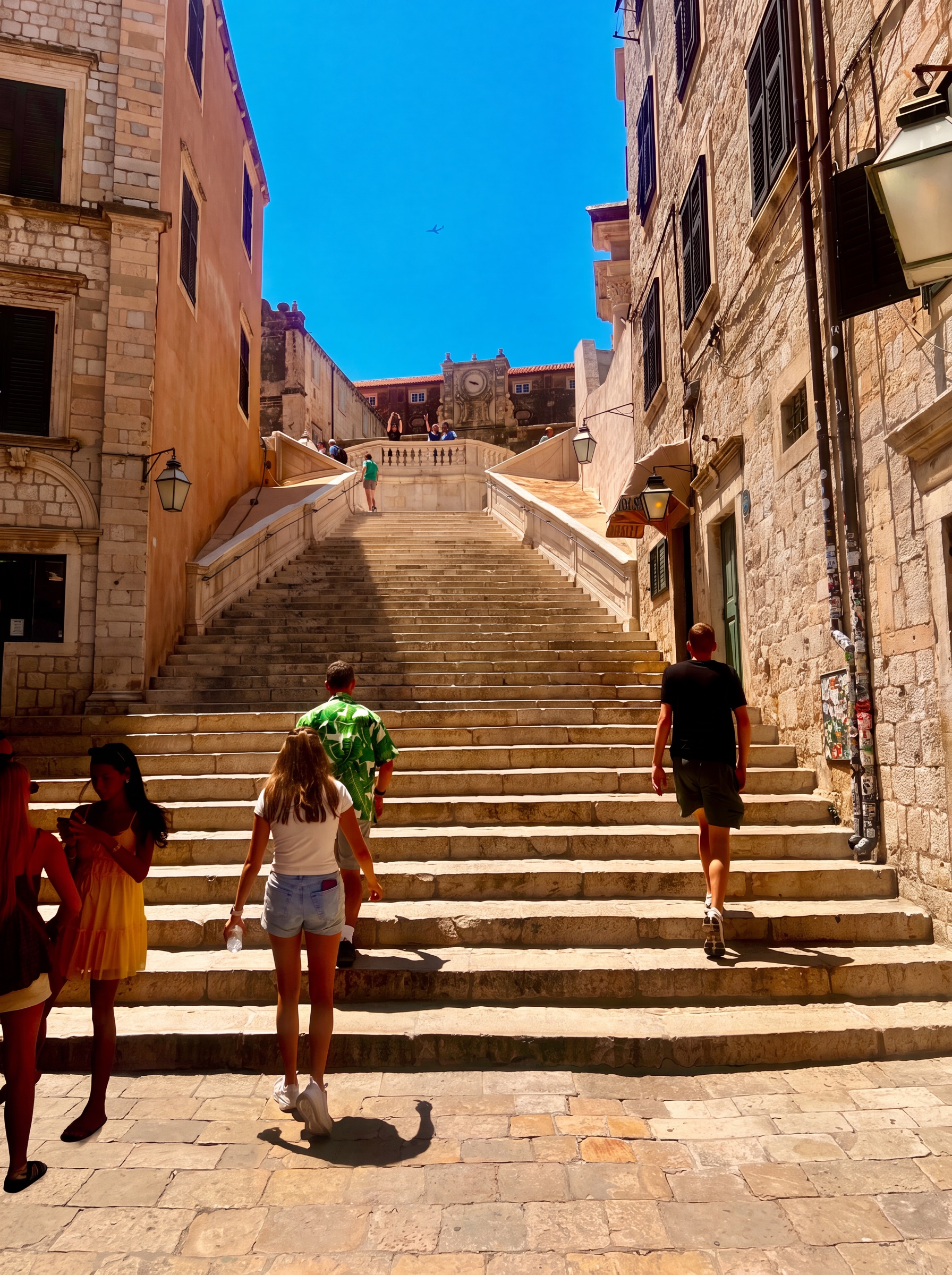 Broad Baroque Jesuit Steps climbing between sunlit stone buildings in Dubrovnik