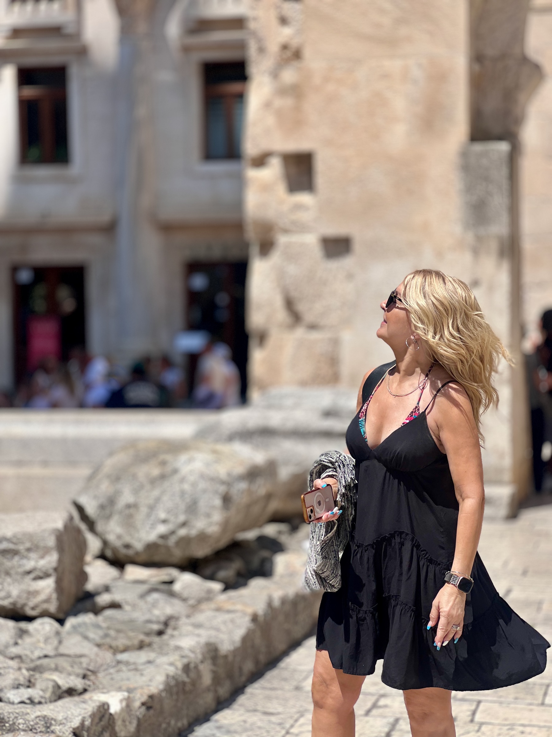 Dianne looking upward while standing among ancient stone remains in Split