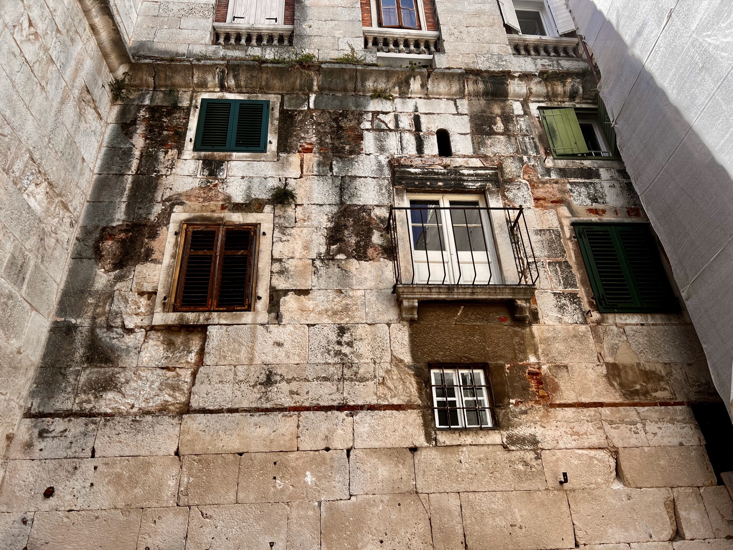 Green shutters and balconies built into the ancient stone walls of Diocletian's Palace