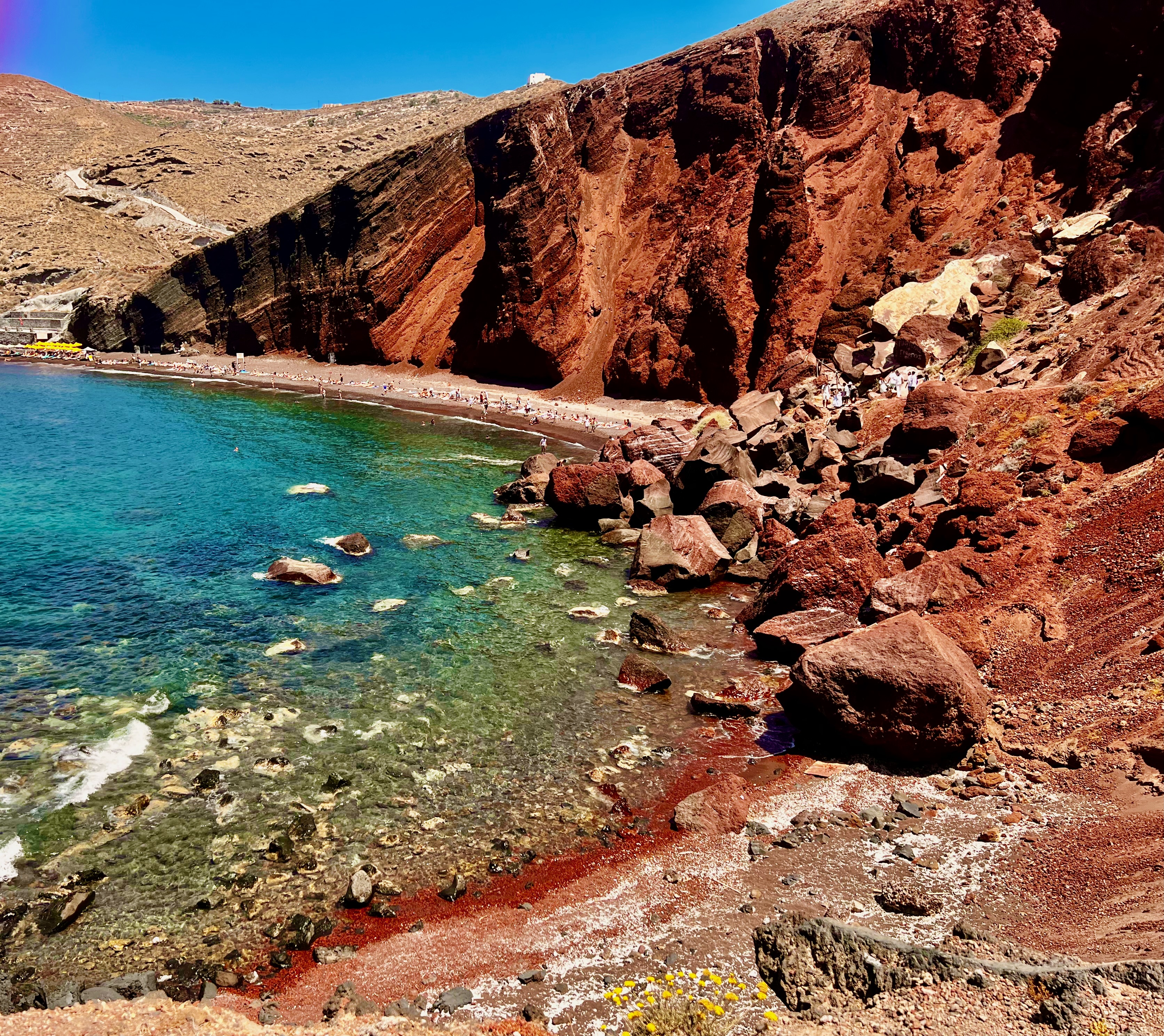 Santorini's red volcanic cliffs descending toward the sea