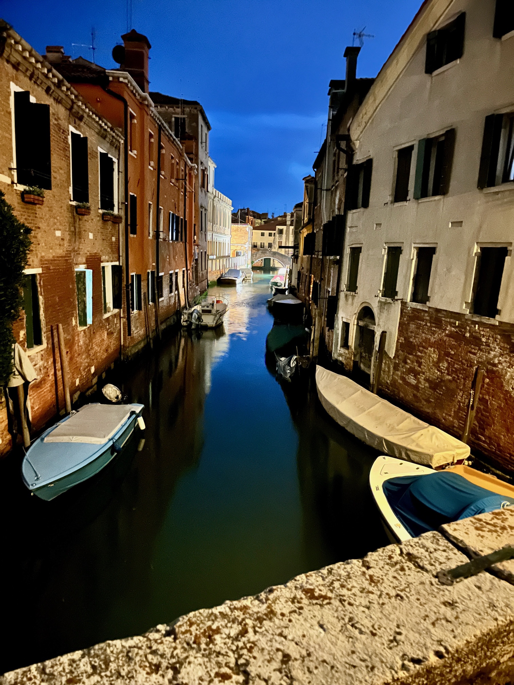 Venetian canal and historic buildings illuminated at blue hour
