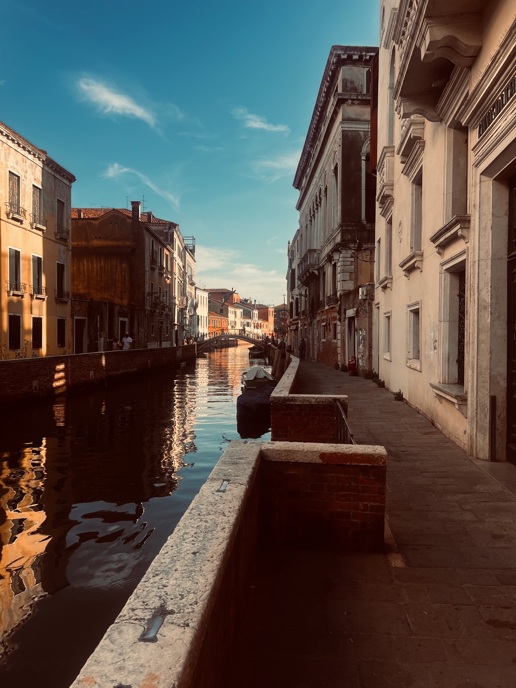 A quiet Venice canal glowing in warm late-afternoon light