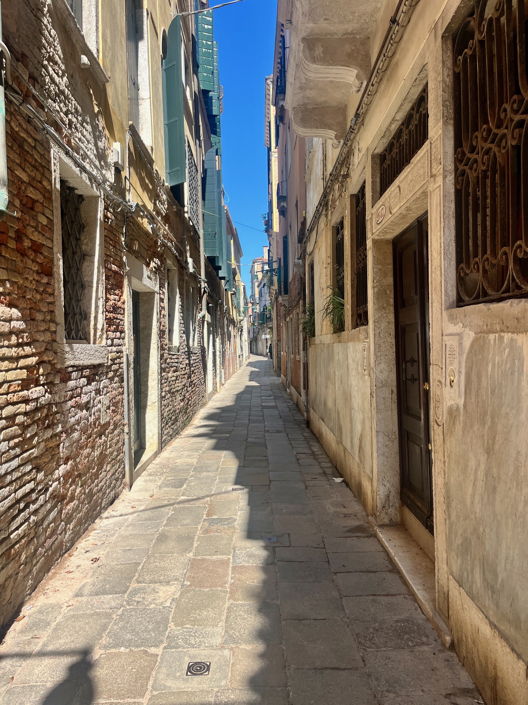 Narrow brick alley winding between old buildings in Venice